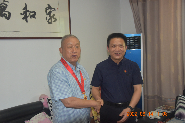 市水利局党组书记、局长孙洲上门颁发“光荣在党50年”纪念章.JPG